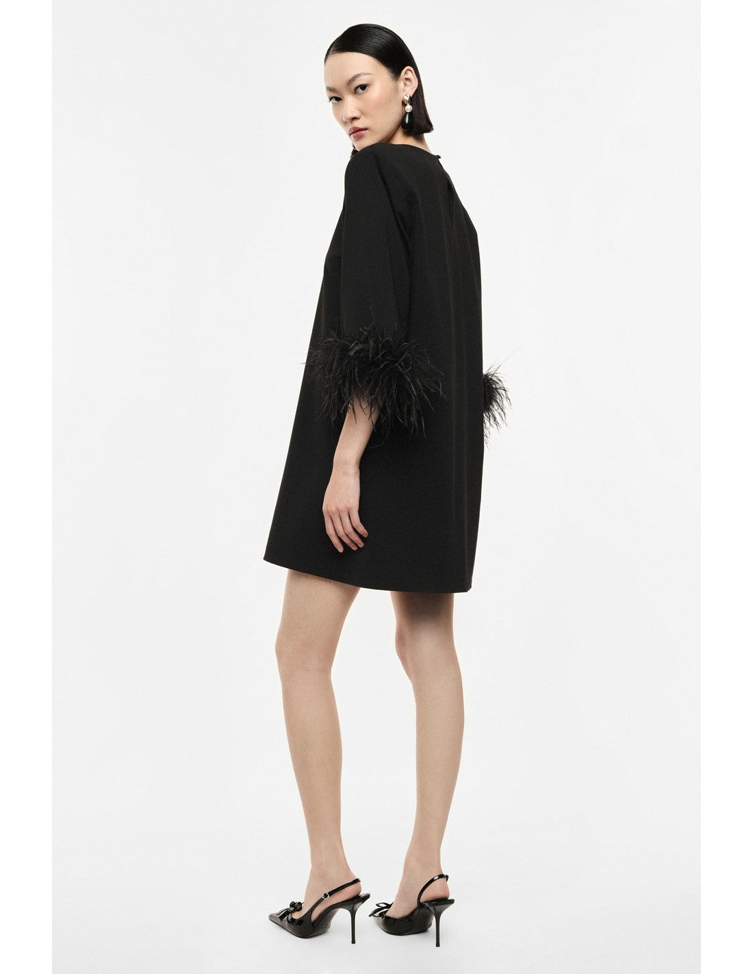 Robe courte à manches bordées de plumes noire portée, profil – Imperial